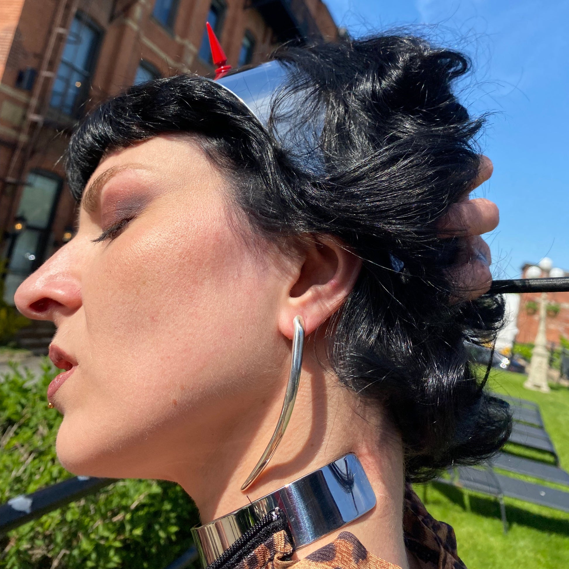 Long sterling silver minimalist curved spike earrings on a dominatrix.